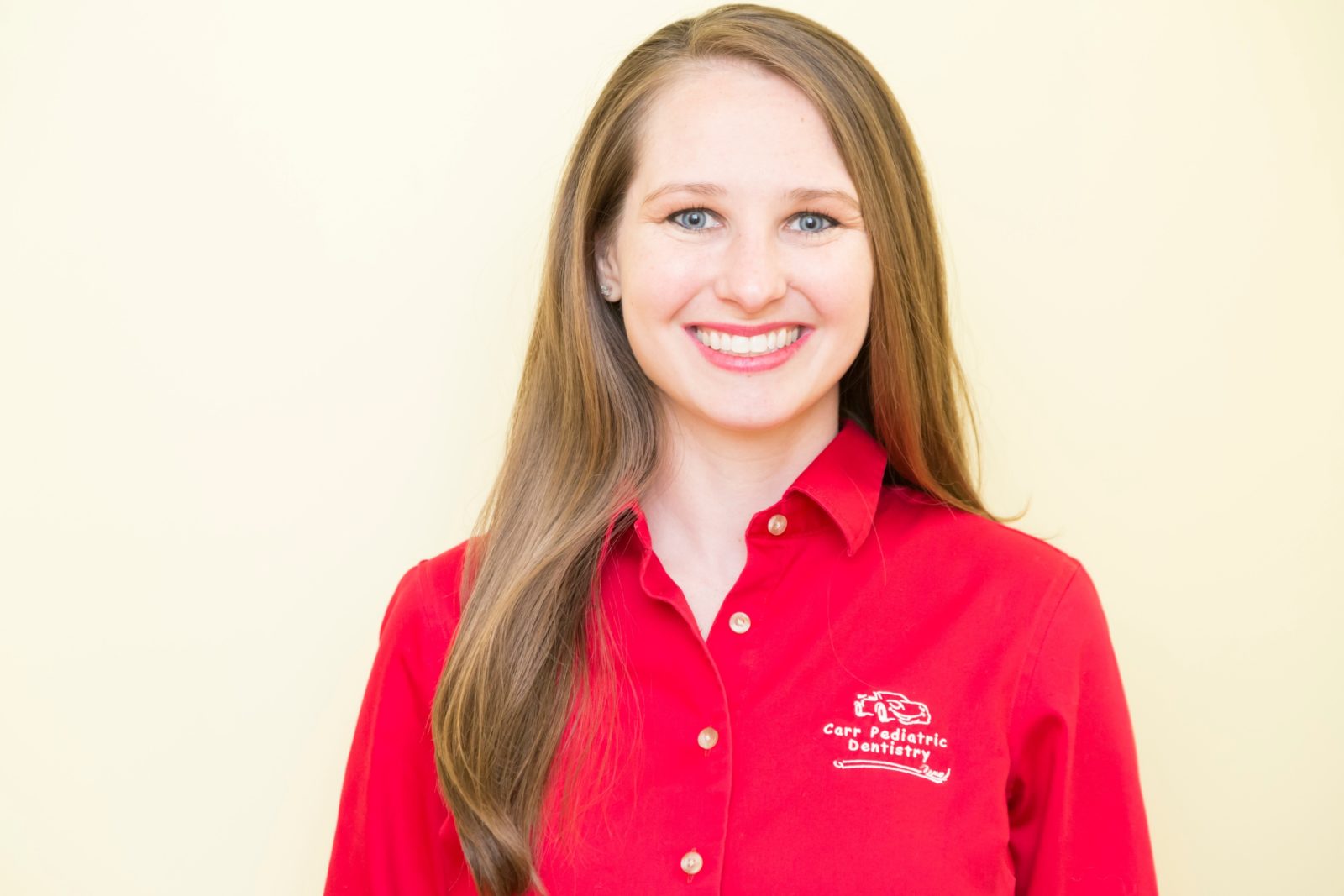 A woman in red shirt smiling for the camera.