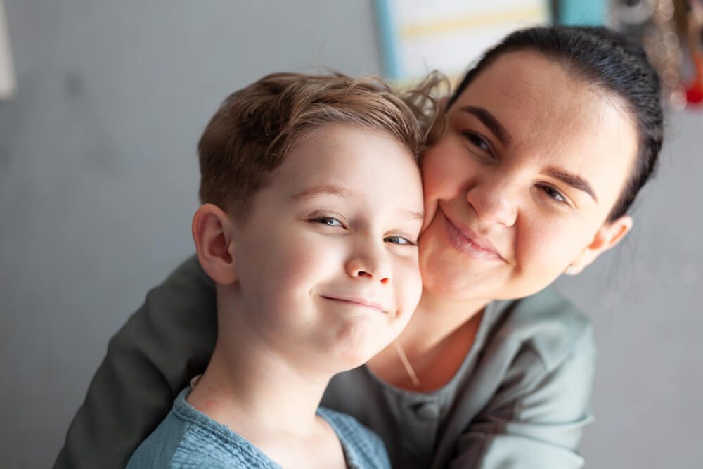 A woman and boy are smiling for the camera.