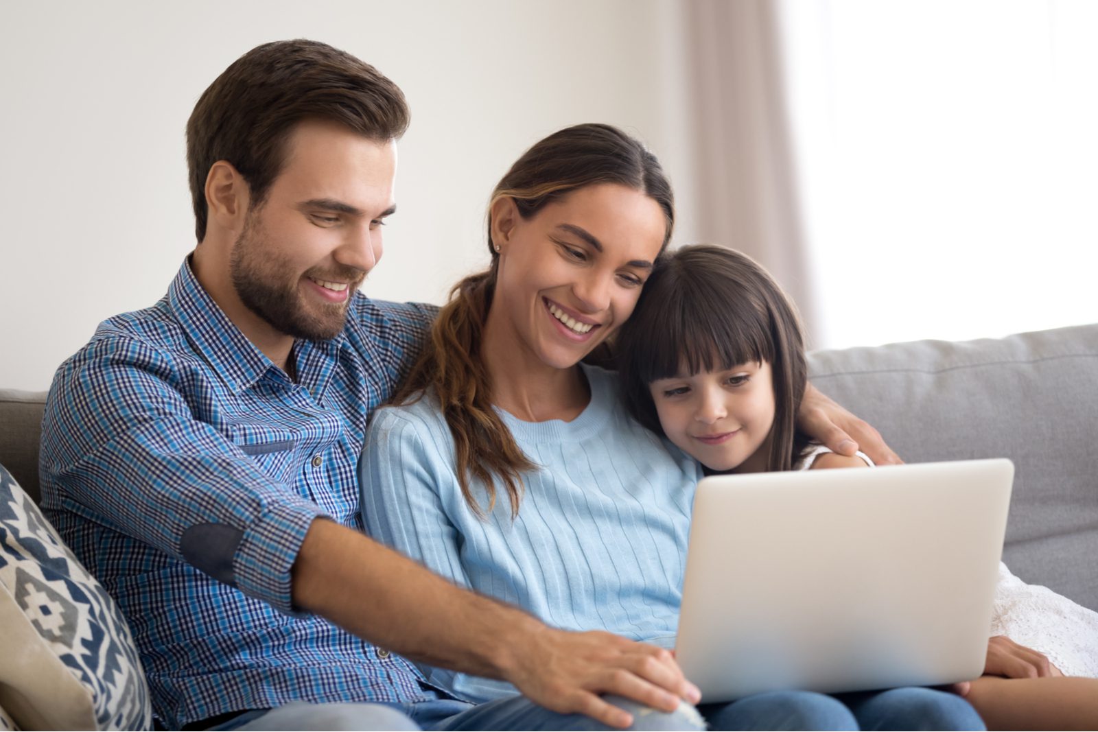 A man and woman sitting on the couch with a girl.