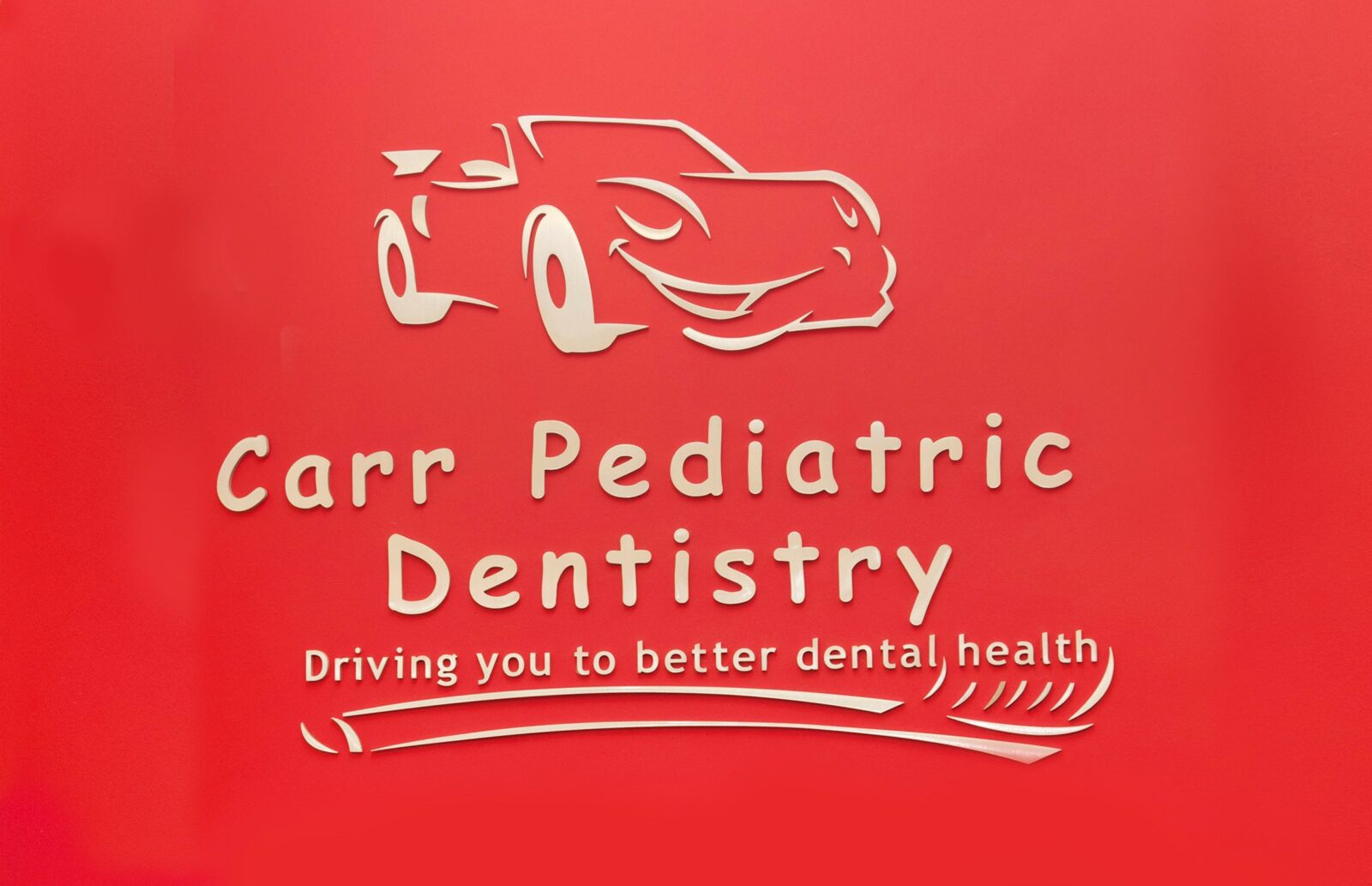 A red sign with the words " carr pediatric dentistry " written in white.